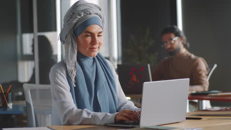 Cheerful-Businesswoman-in-Hijab-Posing-for-Camera-in-Office